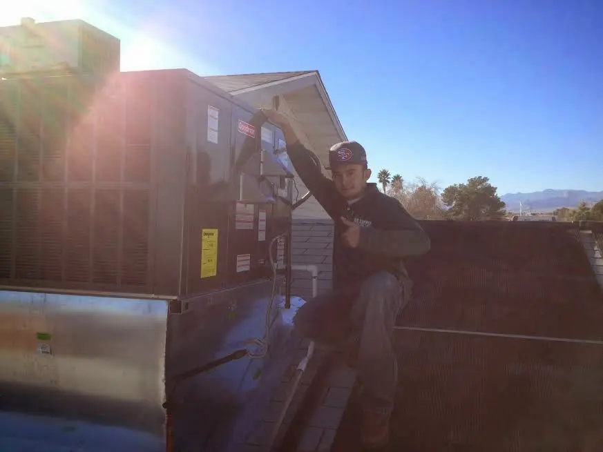 HVAC technician performing Boiler Repair on a rooftop unit in Atascocita